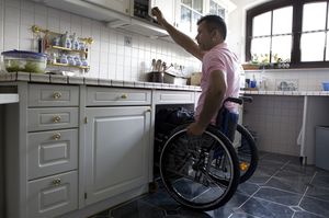 Mann in Rollstuhl in der Küche