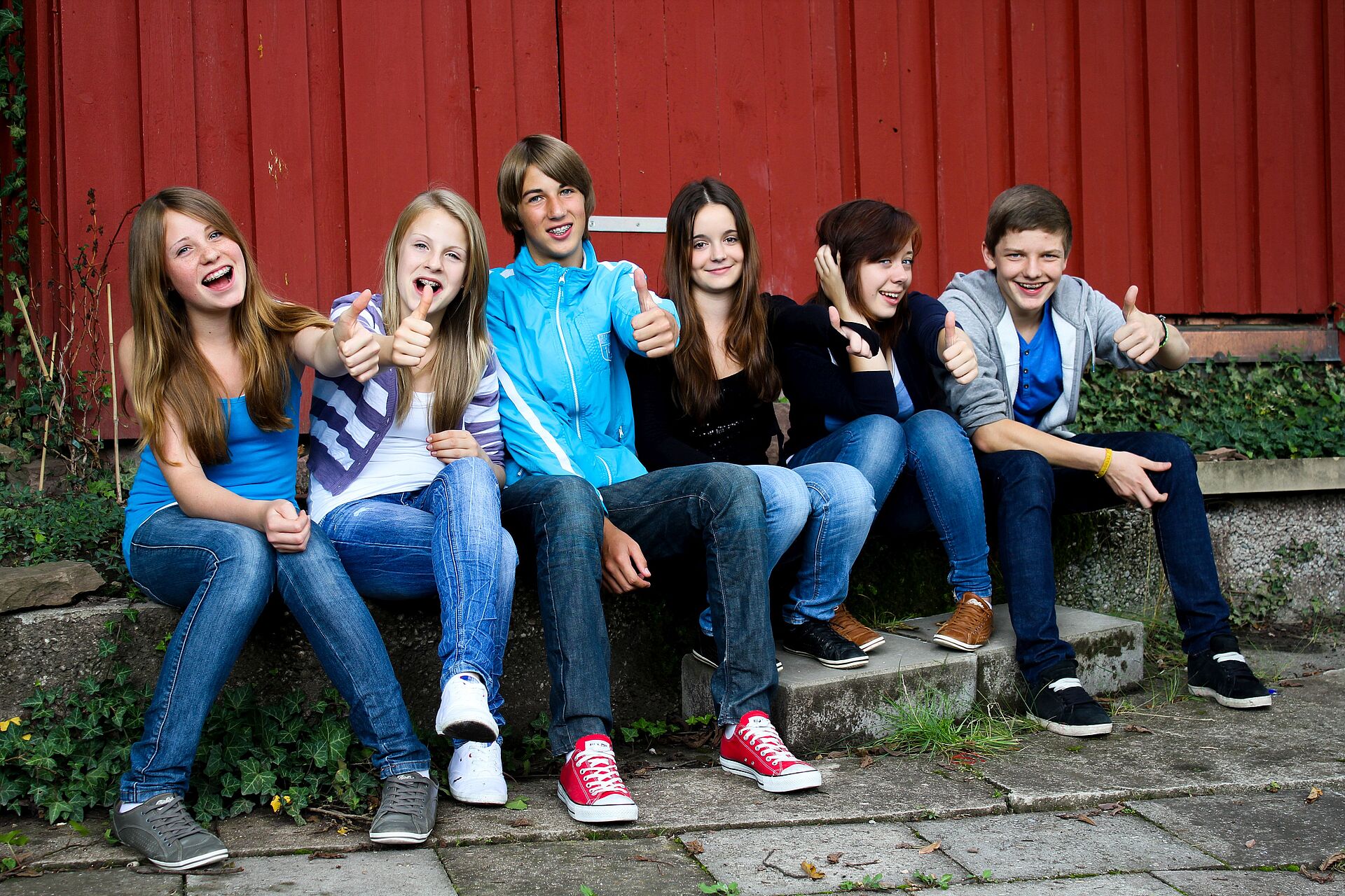 Sechs Jugendliche sitzen nebeneinander