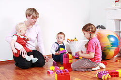 Symbolbild Mutter beim Spielen mit drei Kindern