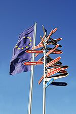 Europe-Flagge und Wegweiser in verschiedene Richtungen