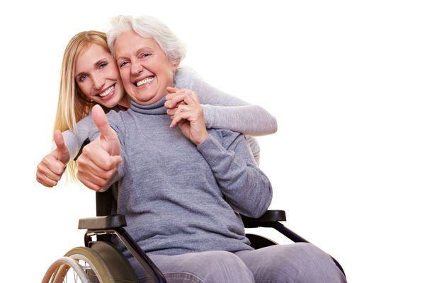 Frau im Rollstuhl und junge Frau zeigen Daumen hoch